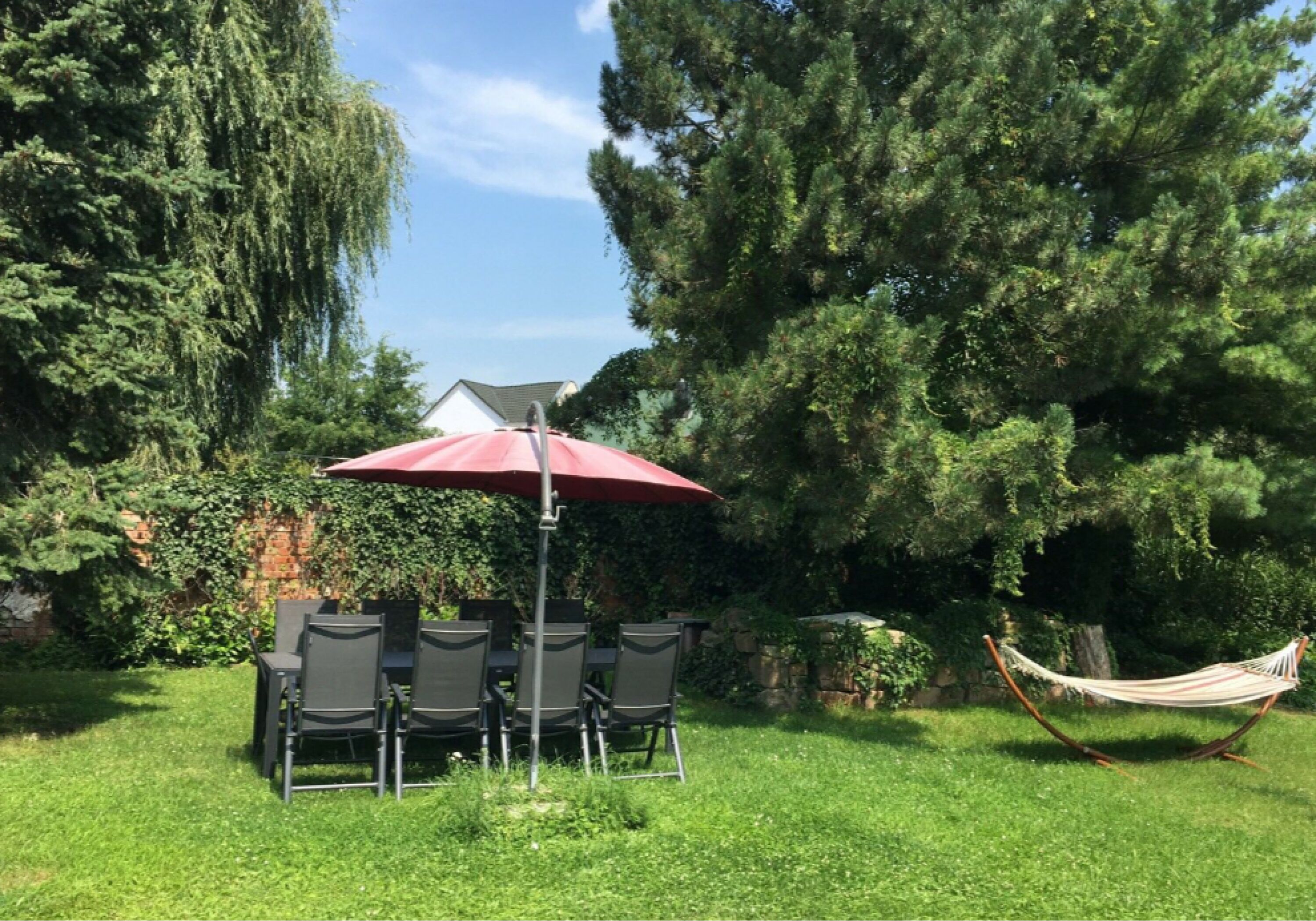 Garten mit Sitzgruppe, Sonnenschirm und Hängematte